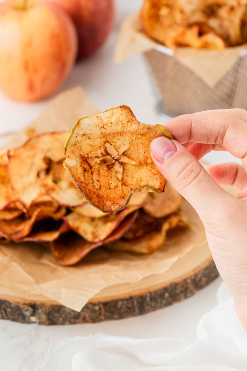 hand holding up an air fryer apple chip