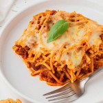 a square piece of air fryer baked spaghetti on a white plate with a fork