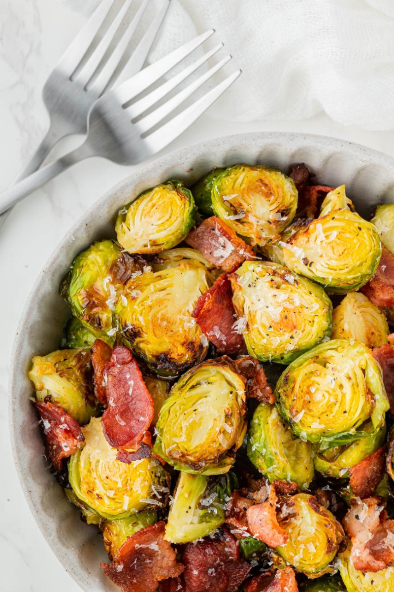 air fryer brussels sprouts with bacon in a bowl with two forks