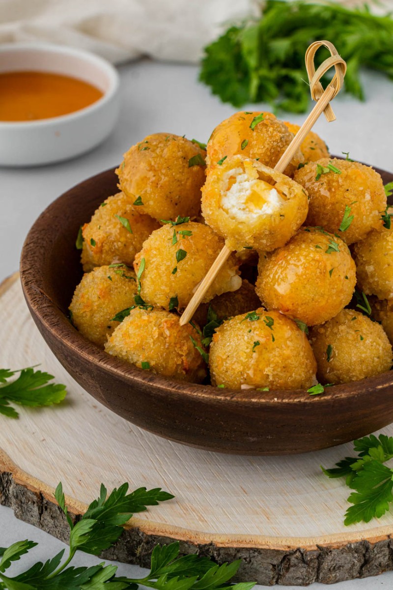 air fryer cheese bites in a bowl with a toothpick in one