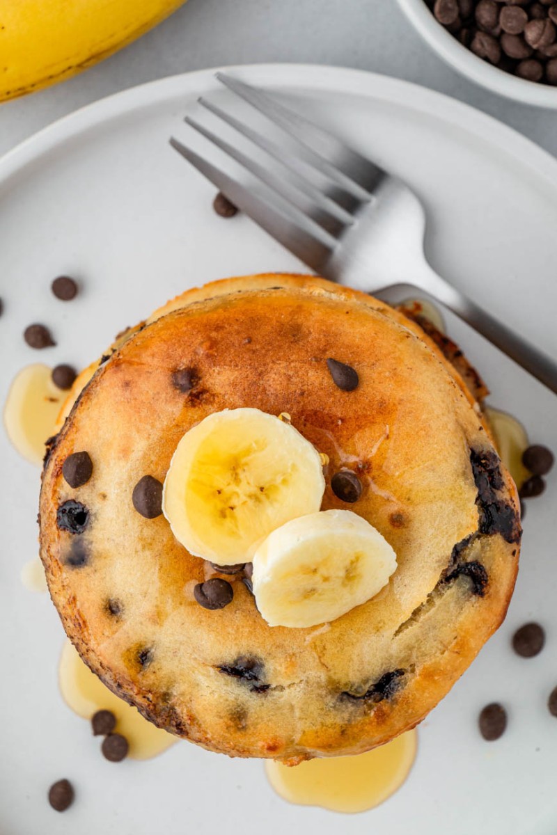 overhead photo of air fryer pancakes with bananas and a fork on a plate