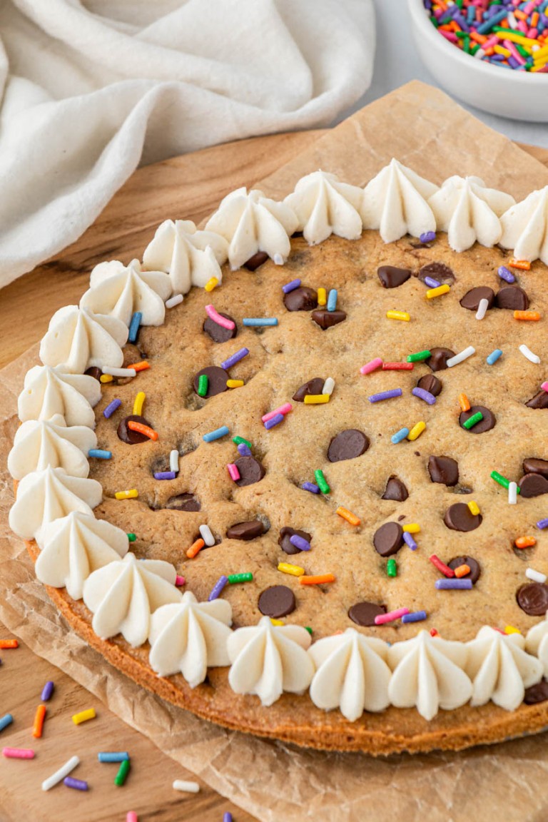 air fryer cookie cake on a wood board with rainbow sprinkles