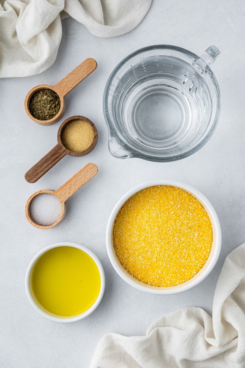instant polenta, water, oil, and spices in small ingredient bowls