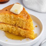 air fryer cornbread on a white plate with butter on top