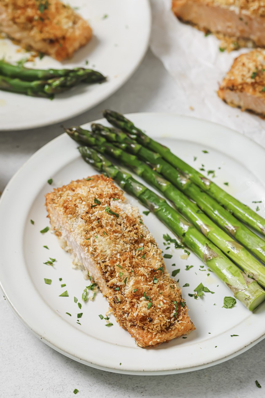 Panko crusted salmon on a plate with asparagus.