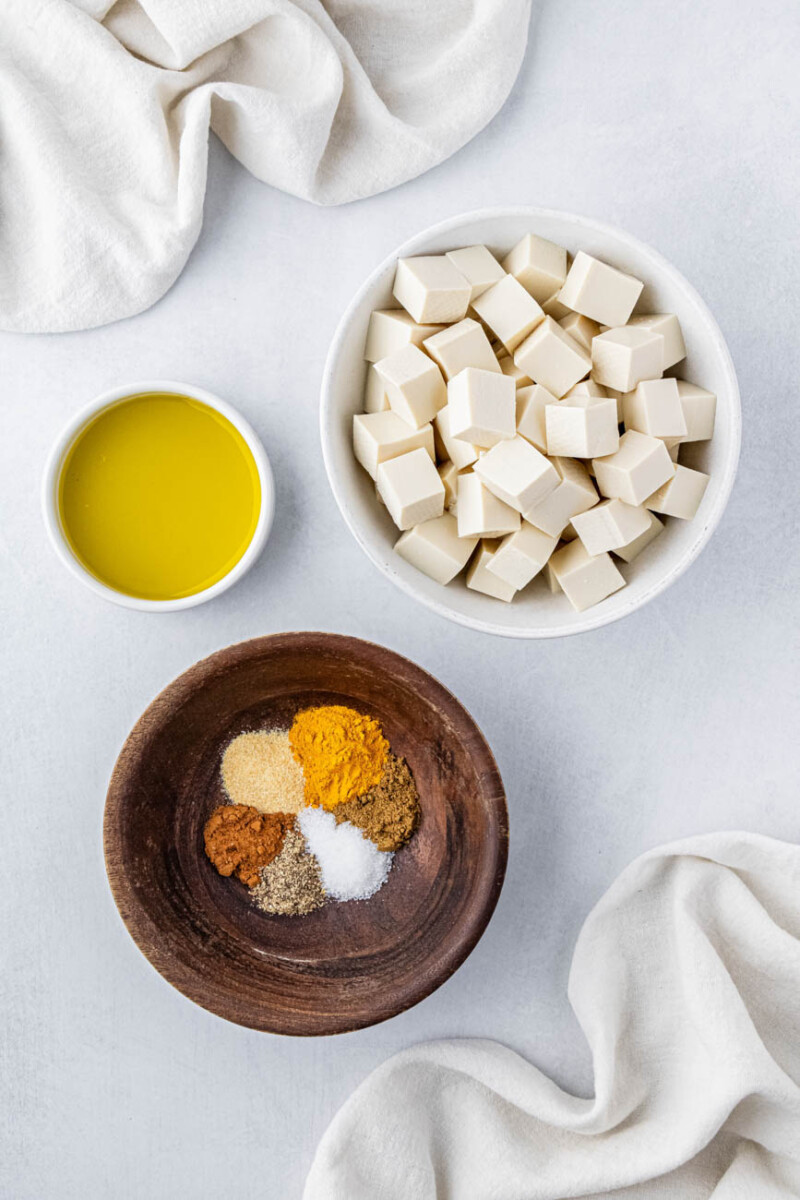 cubed tofu, spices, and olive oil in small ingredient bowls