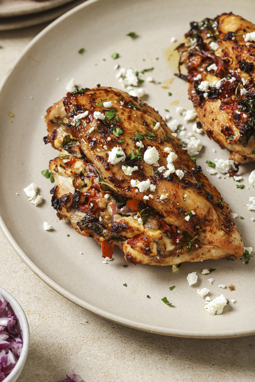 Close up of air fryer stuffed chicken breast on a white plate.