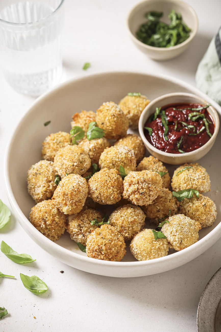 A bowl of air fryer mozzarella balls with marinara sauce.