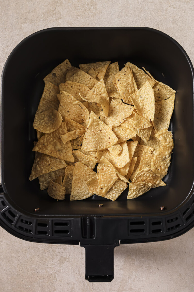 Tortilla chips in an air fryer basket.