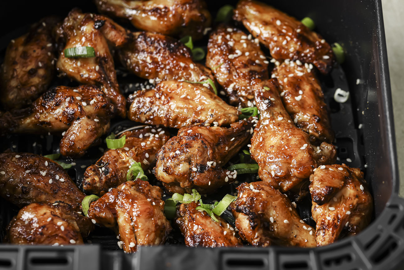 Side view of air fryer asian wings in the air fryer basket.