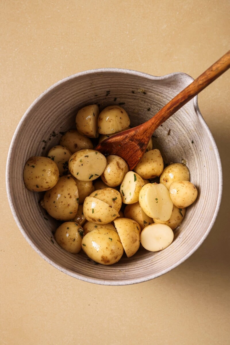 Tossing potatoes with oil and herbs.