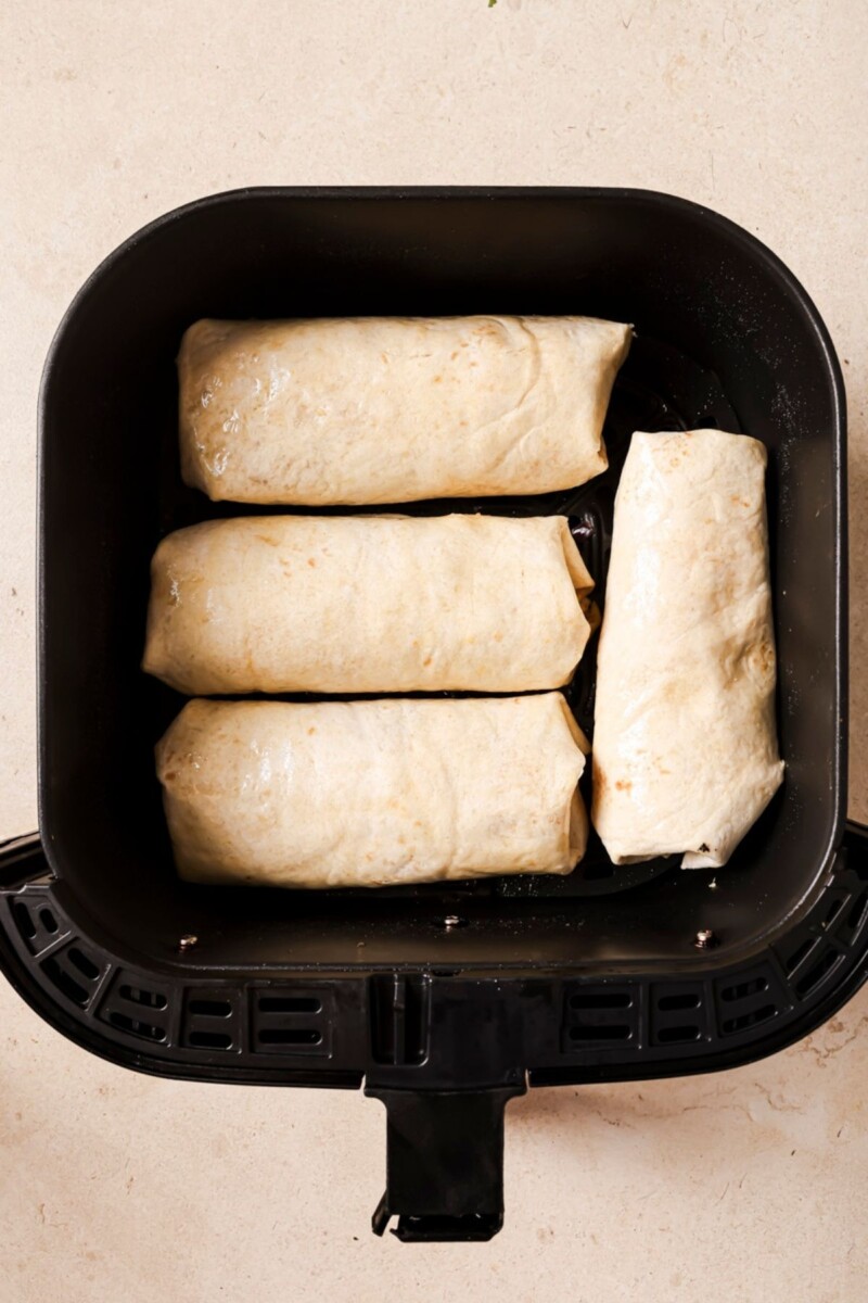 Air fryer breakfast burritos in the air fryer.