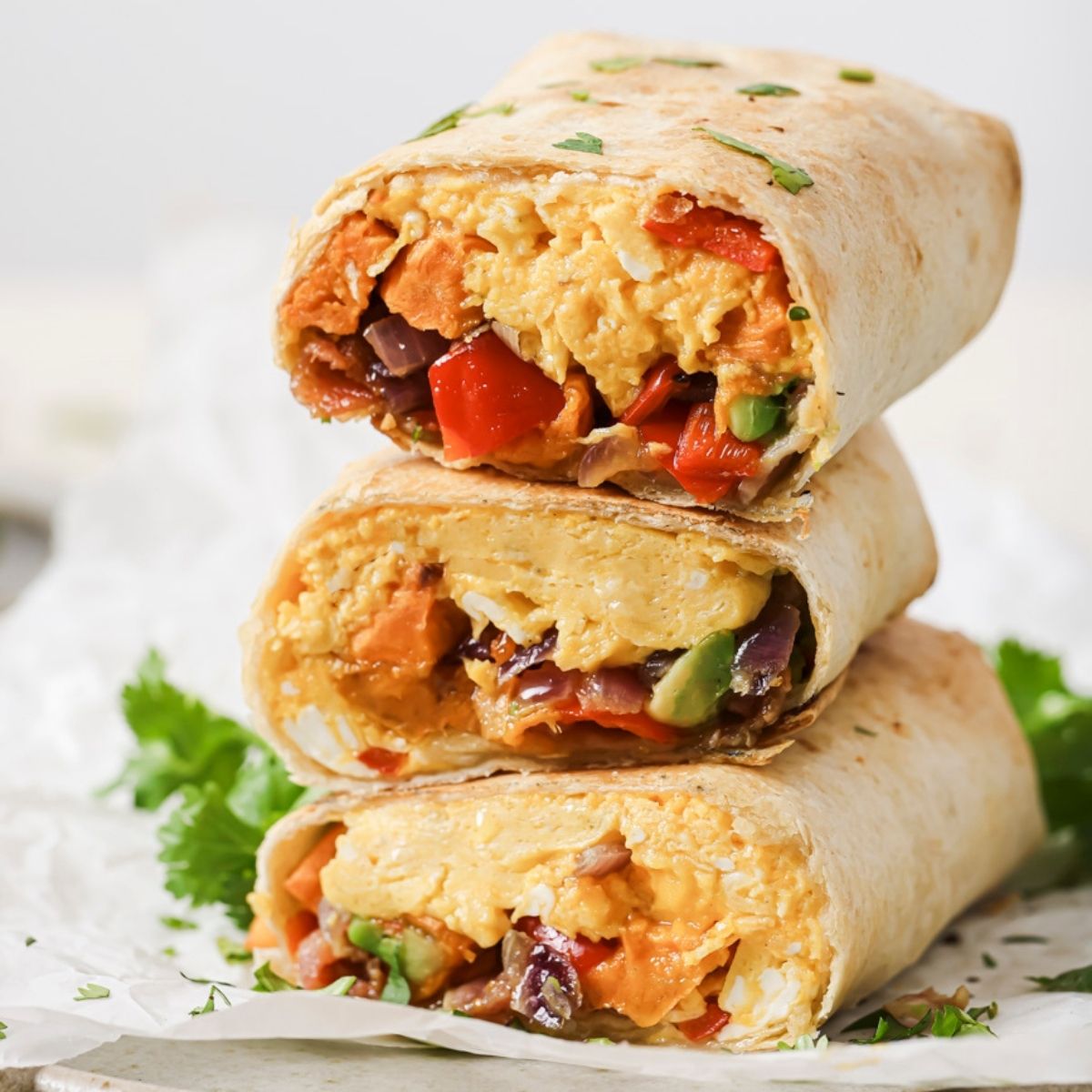 Three air fryer breakfast burrito halves in a stack.