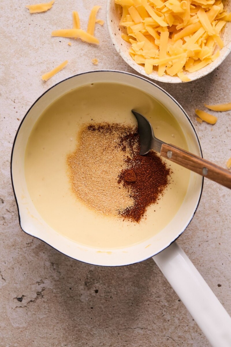 Stirring spices into cheese sauce.